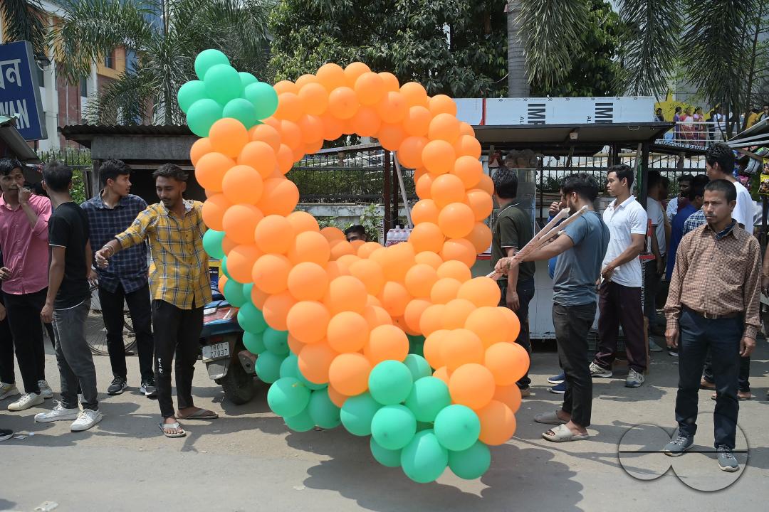 Supporters of the BJP are seen decorating balloons in the party's colours at a rally featuring Tripura Chief Minister Manik Saha, former CM and BJP candidate Biplab Kumar Deb, and Kriti Singh, alongside other leaders, during an election campaign rally in