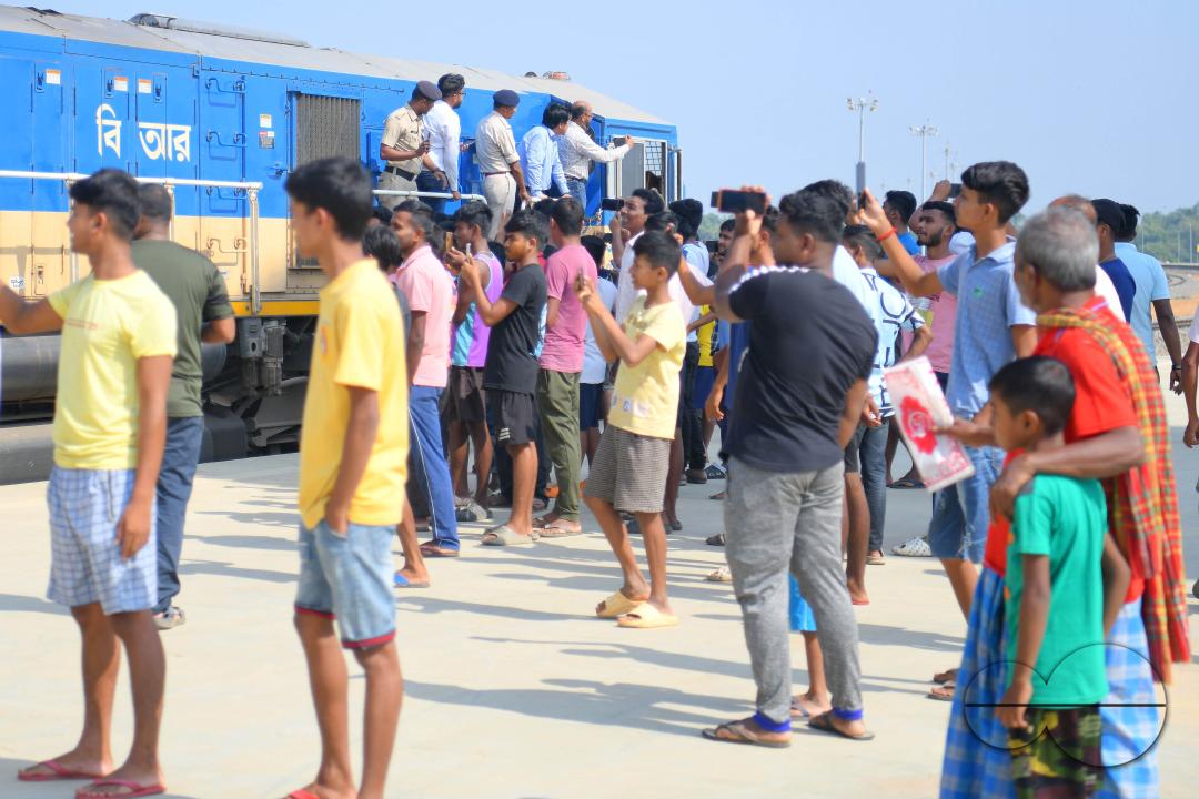 Indian people looking at a trial train and taking photographs, which is crossing the Indo-Bangladesh border
