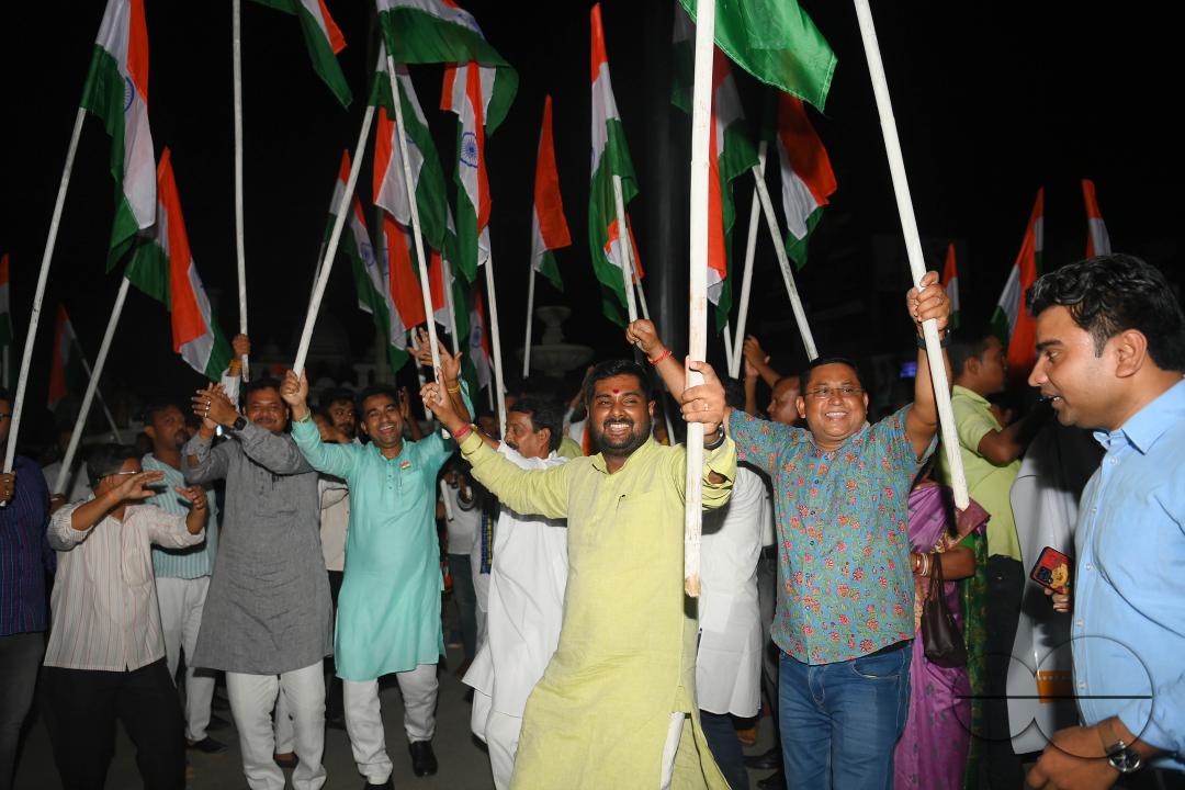 BJP party leaders, workers and the general public celebrate with the Indian flag in front of a LCD TV during the live stream of the successful lunar landing of the Chandrayaan-3 spacecraft on the south pole of the Moon, in Agartala