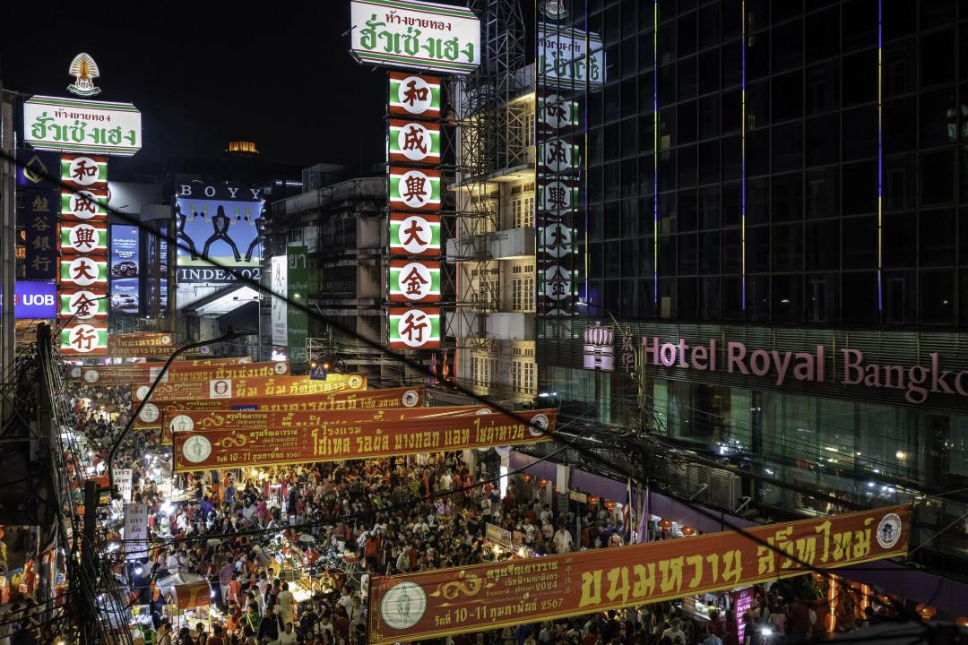 View of the crowded street of Yaowarat Road with people celebrating the Chinese New Year 2024 Festival in Chinatown, Bangkok, Thailand.