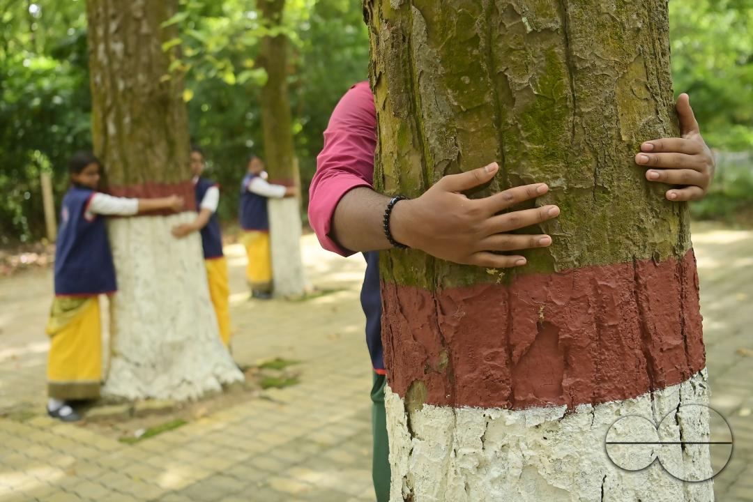 NSS (National Service Scheme) volunteers and school students of Netaji Subhas Vidyaniketan hug trees on the eve of World Nature Conservation Day