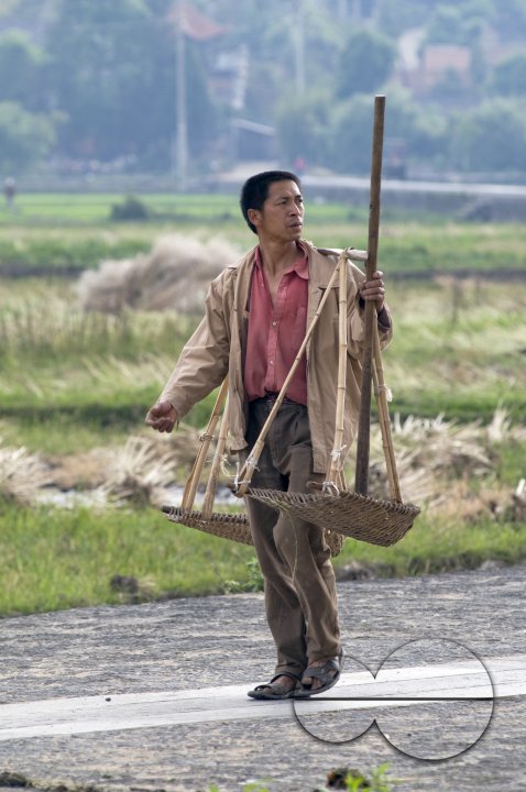 CHINA Peasant with farming tools in Yunnan province.