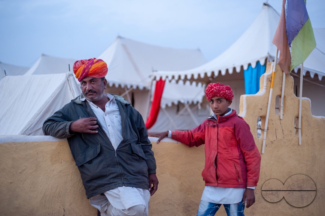 Musicians who perform for tourists in the desert wait outside the premises at dusk.