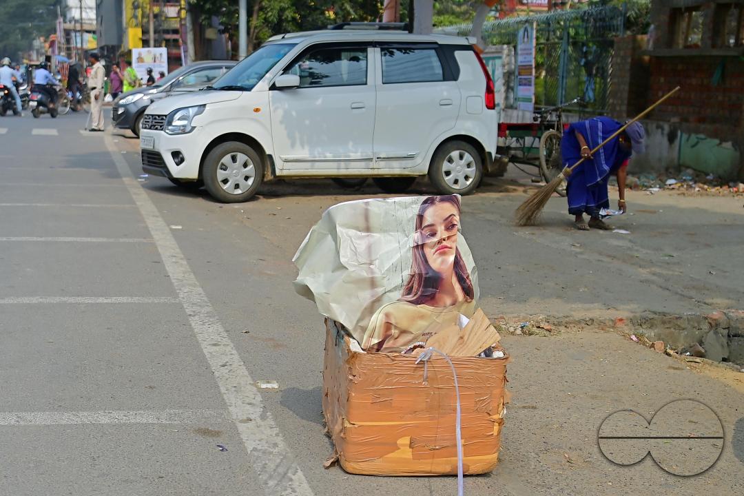 An employee of the municipality sweeps and collects garbage into a collection box in Agartala