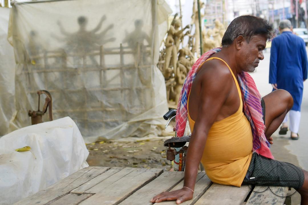 An idol maker is taking a rest after finishing an idol of the Mother Goddess Durga in a studio, ahead of the Durga Puja festival in Agartala, Tripura, India.