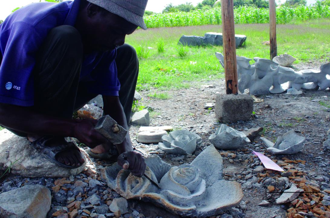 Raphael Machinjili, a sculptor at Tafara Mabvuku Arts Association is seen working on his stone roses