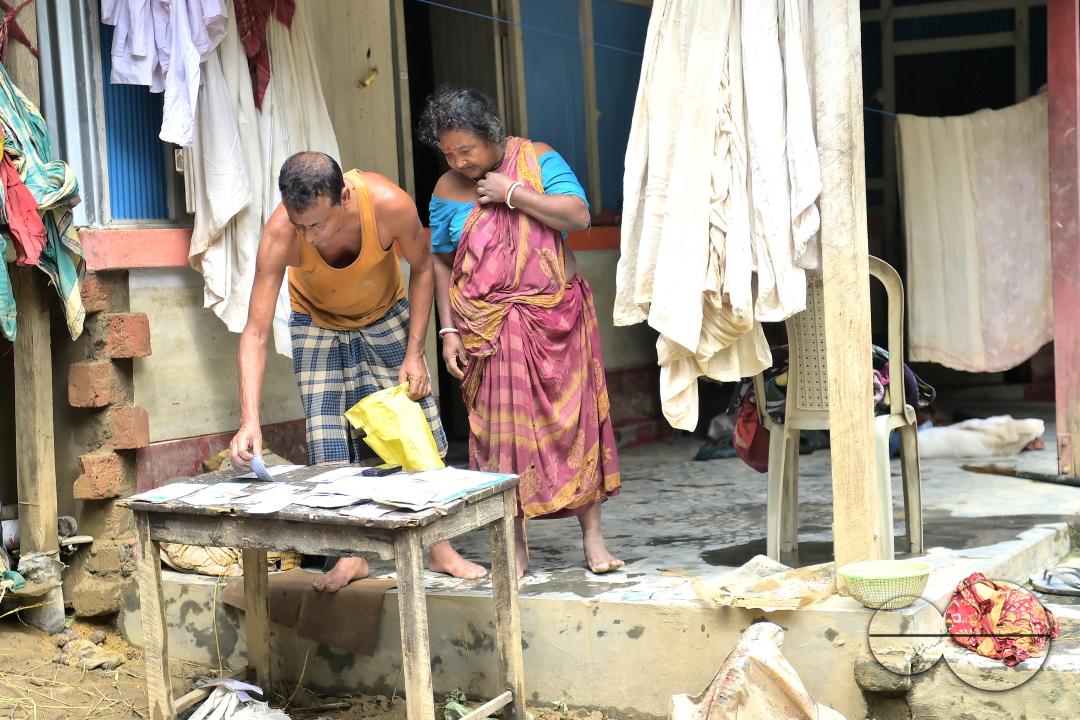 A couple is seen trying to dry their important documents that got wet in floodwaters on the outskirts of Amarpur city, about 82 km away from Agartala