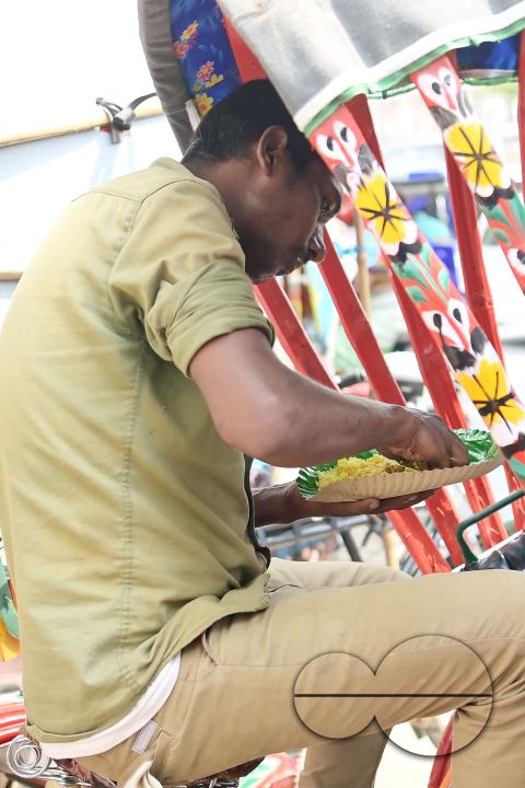 A rickshaw puller eats food distributed by a social worker on World Food Safety Day organised by Rotary Club of Agartala, in Agartala