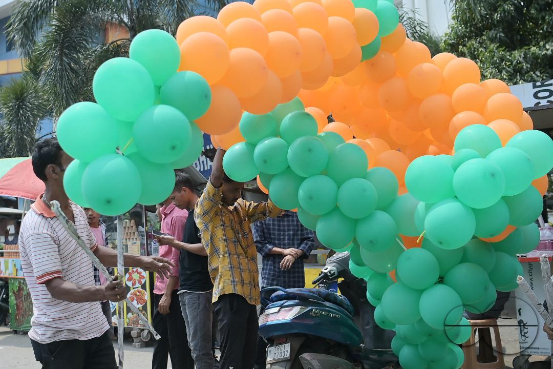 Supporters of the BJP are seen decorating balloons in the party's colours at a rally featuring Tripura Chief Minister Manik Saha, former CM and BJP candidate Biplab Kumar Deb, and Kriti Singh, alongside other leaders, during an election campaign rally in